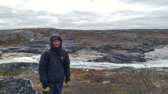 Charlie Kowcharlie standing at the point where the future hydro project is planned to cross the Innuksuak river