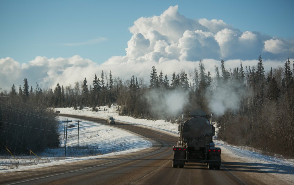 Steam from oil production facilities blankets the horizon along a highway near a Fort McKay First Nation reserve in Alberta. Since the band began doing business with the oil industry in 1986, its corporation’s annual revenue has grown to $73 million. Darren Hauck for Reveal